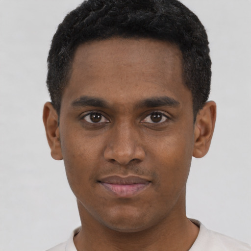 Joyful black young-adult male with short  brown hair and brown eyes