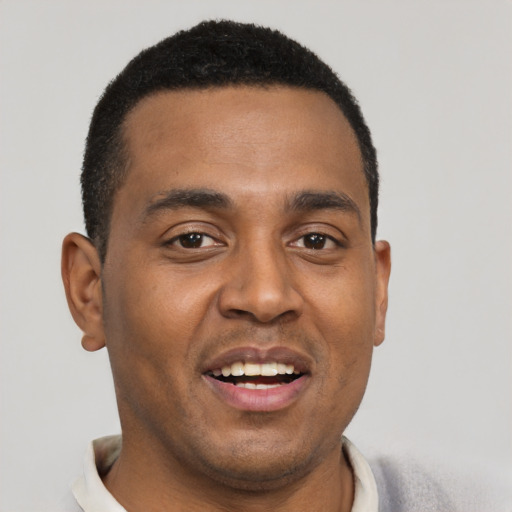 Joyful black young-adult male with short  black hair and brown eyes
