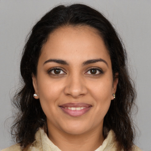 Joyful latino young-adult female with medium  brown hair and brown eyes