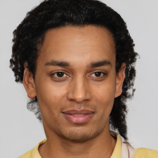 Joyful black young-adult male with short  black hair and brown eyes