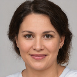 Joyful white adult female with medium  brown hair and brown eyes