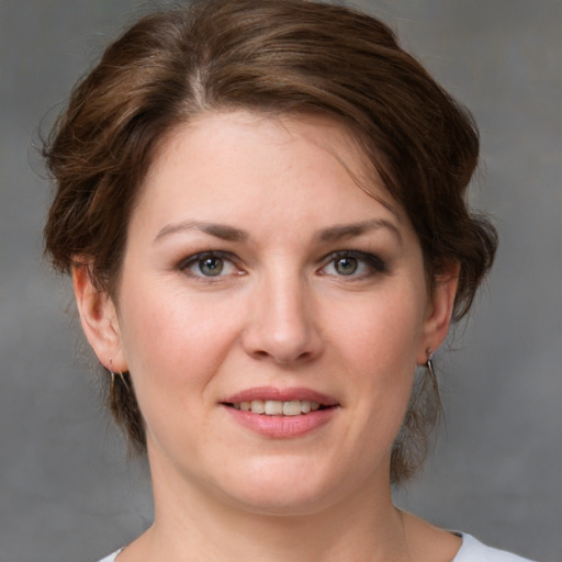 Joyful white young-adult female with medium  brown hair and grey eyes