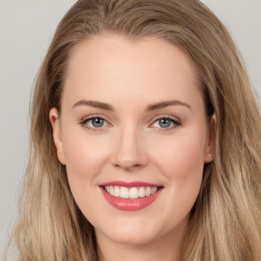 Joyful white young-adult female with long  brown hair and grey eyes