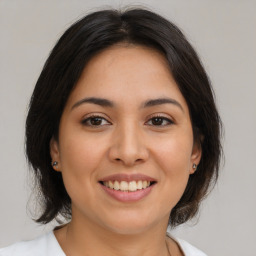 Joyful latino young-adult female with medium  brown hair and brown eyes