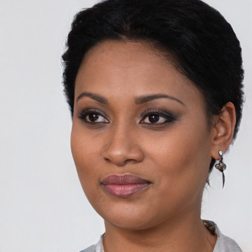 Joyful latino young-adult female with short  black hair and brown eyes