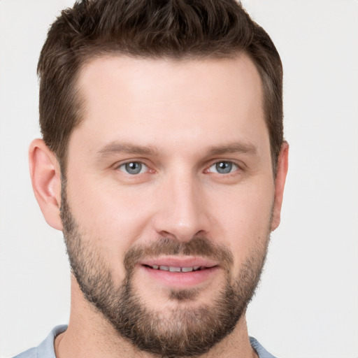 Joyful white young-adult male with short  brown hair and grey eyes