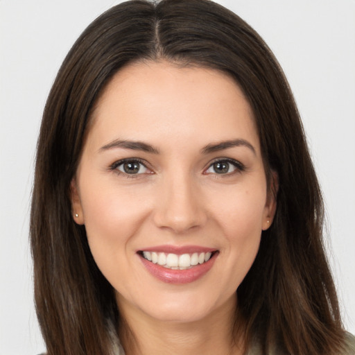 Joyful white young-adult female with long  brown hair and brown eyes