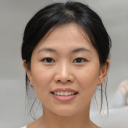 Joyful asian young-adult female with medium  brown hair and brown eyes