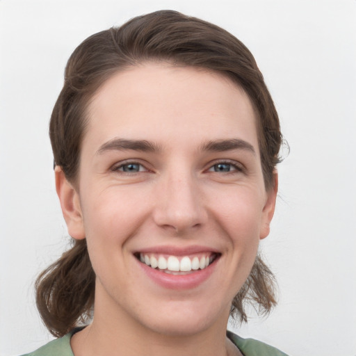 Joyful white young-adult female with medium  brown hair and grey eyes