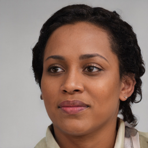 Joyful black young-adult female with medium  black hair and brown eyes