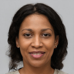 Joyful black adult female with medium  brown hair and brown eyes