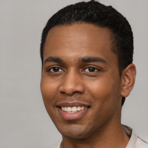 Joyful black young-adult male with short  black hair and brown eyes