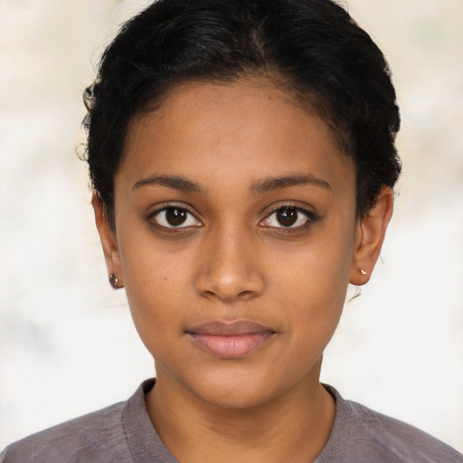 Joyful black young-adult female with short  black hair and brown eyes