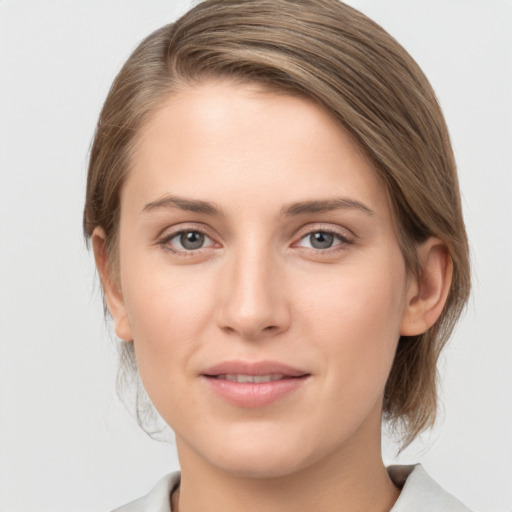 Joyful white young-adult female with medium  brown hair and grey eyes