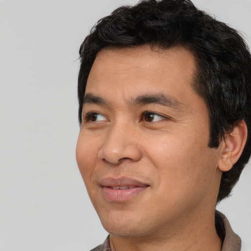 Joyful white adult male with short  black hair and brown eyes