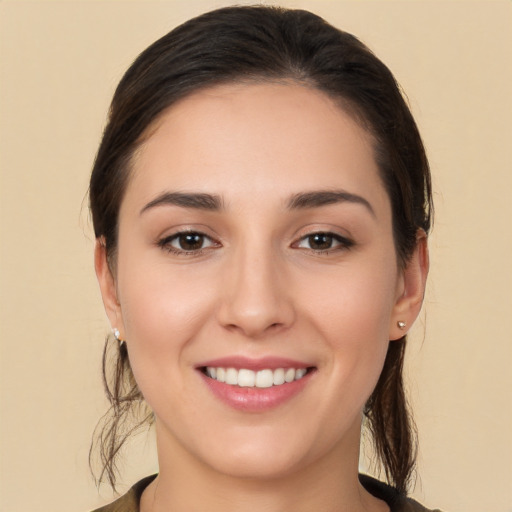 Joyful white young-adult female with long  brown hair and brown eyes