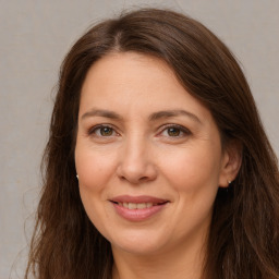 Joyful white adult female with long  brown hair and brown eyes