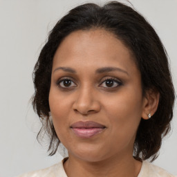 Joyful black adult female with medium  brown hair and brown eyes