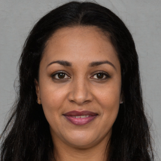 Joyful latino adult female with long  brown hair and brown eyes