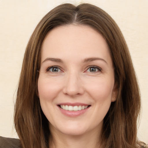 Joyful white young-adult female with long  brown hair and green eyes