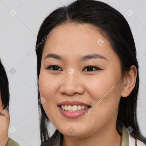 Joyful asian young-adult female with medium  black hair and brown eyes