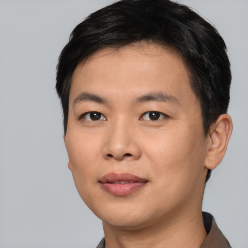 Joyful asian young-adult male with short  black hair and brown eyes