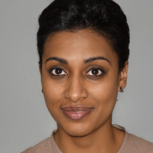 Joyful black young-adult female with short  black hair and brown eyes
