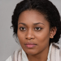 Joyful black young-adult female with long  brown hair and brown eyes