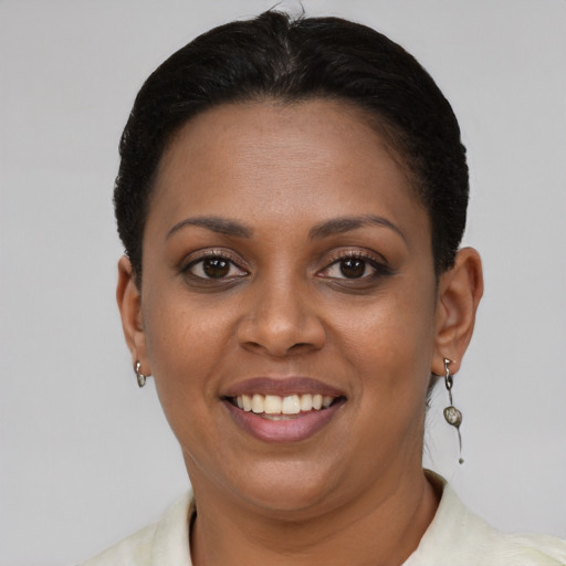 Joyful black young-adult female with short  brown hair and brown eyes