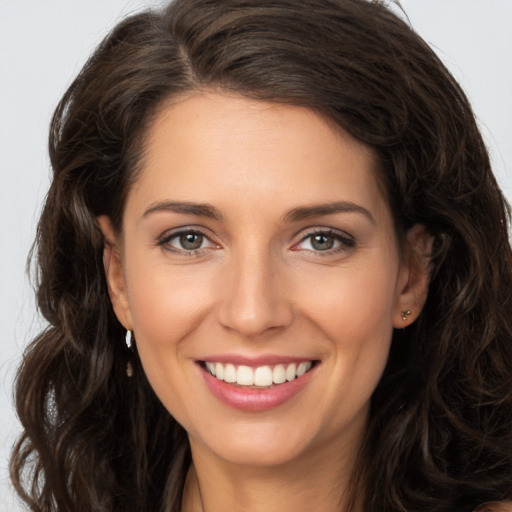 Joyful white young-adult female with long  brown hair and brown eyes