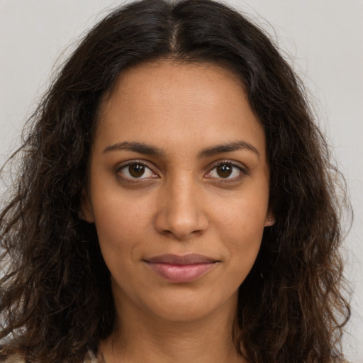 Joyful latino young-adult female with long  brown hair and brown eyes