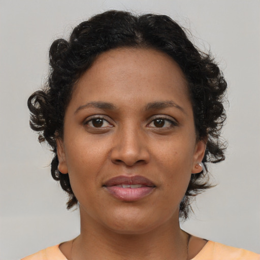 Joyful black young-adult female with short  brown hair and brown eyes