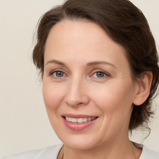 Joyful white adult female with medium  brown hair and grey eyes