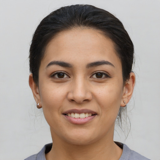 Joyful latino young-adult female with short  brown hair and brown eyes