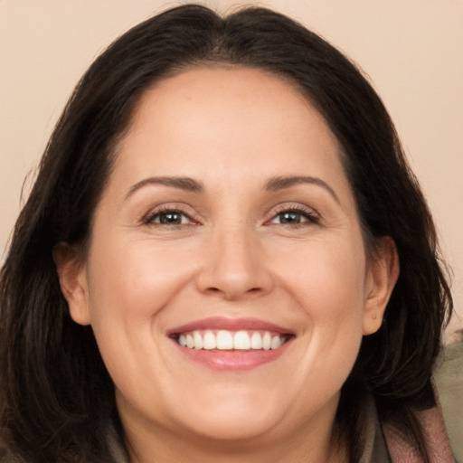 Joyful white adult female with long  brown hair and brown eyes