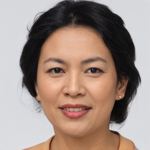 Joyful asian adult female with medium  brown hair and brown eyes