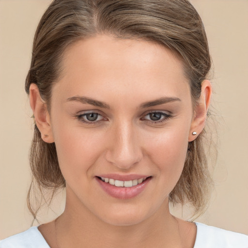 Joyful white young-adult female with medium  brown hair and grey eyes