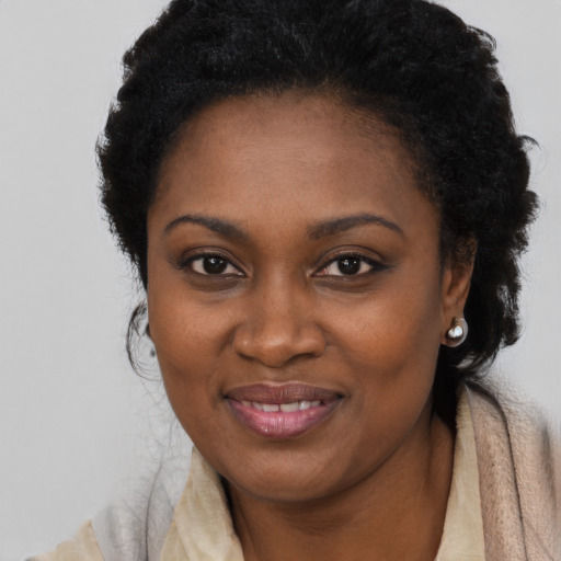 Joyful black young-adult female with long  black hair and brown eyes