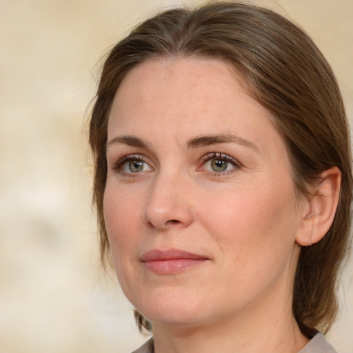 Joyful white adult female with medium  brown hair and green eyes