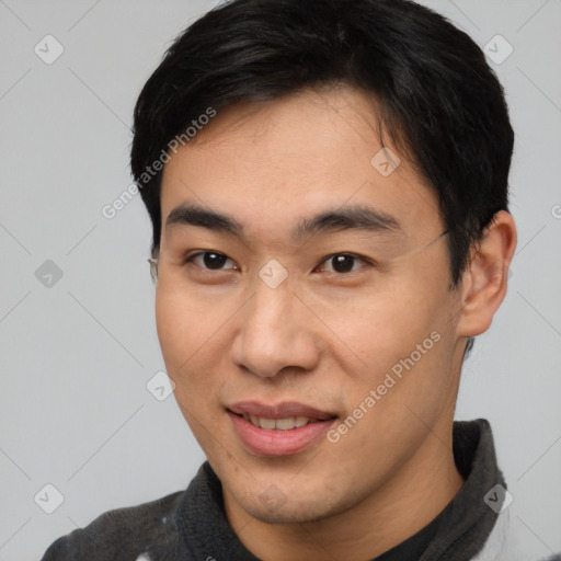 Joyful asian young-adult male with short  black hair and brown eyes