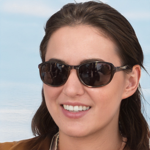 Joyful white young-adult female with long  brown hair and blue eyes