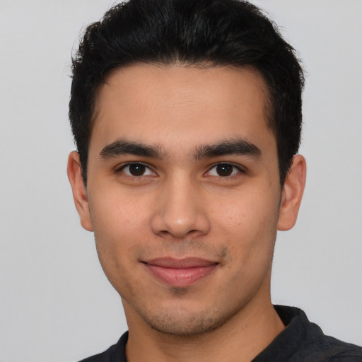 Joyful latino young-adult male with short  black hair and brown eyes