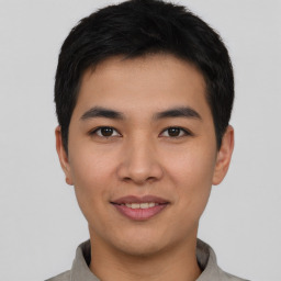 Joyful asian young-adult male with short  black hair and brown eyes