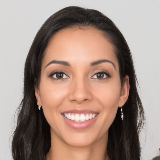 Joyful latino young-adult female with long  brown hair and brown eyes