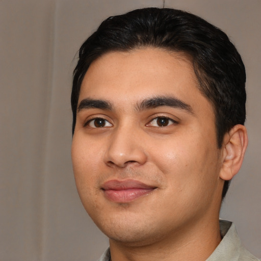 Joyful latino young-adult male with short  black hair and brown eyes