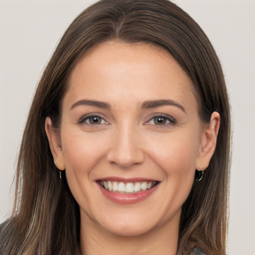 Joyful white young-adult female with long  brown hair and brown eyes