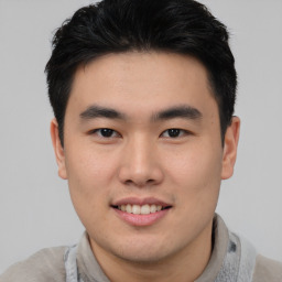 Joyful asian young-adult male with short  brown hair and brown eyes