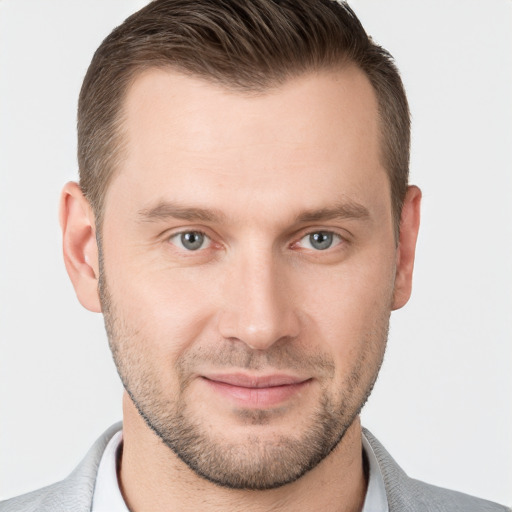 Joyful white young-adult male with short  brown hair and grey eyes