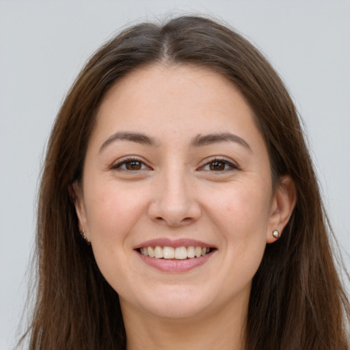 Joyful white young-adult female with long  brown hair and brown eyes