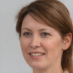 Joyful white adult female with medium  brown hair and grey eyes